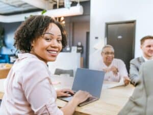ragazza con contratto di apprendistato sorride mentre lavora al pc