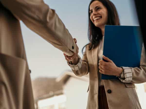 una giovane assunta stringe la mano al nuovo datore di lavoro