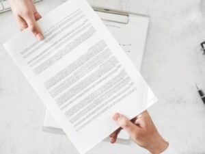 Una persona tiene in mano un contratto di prestazione di servizi