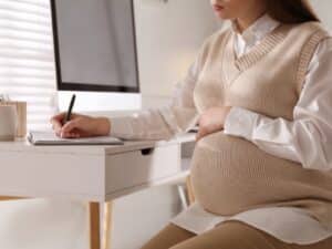 donna incinta al lavoro pronta per richiedere un congedo maternità