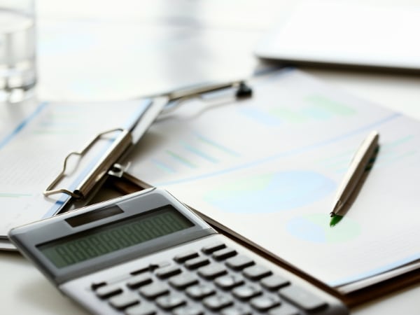 Documenti di lavoro e calcolatrice utilizzati per correggere errori in busta paga