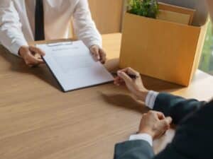 Consegna di una lettera di dimissioni su un tavolo con l'indennità sostitutiva di preavviso