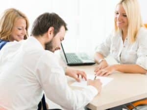 Dipendenti che discutono e firmano documenti relativi all'inquadramento contrattuale durante una riunione.