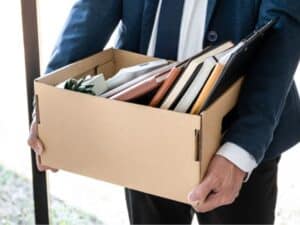 Un dirigente tiene una scatola con oggetti personali, simbolo di un licenziamento ad nutum appena avvenuto.
