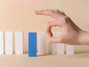 Una mano elimina un oggetto dalla fila, rappresentando un intervento di licenziamento ad nutum.