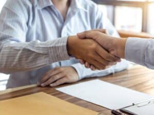 Due persone si stringono la mano dopo aver finalizzato l'accordo sull'inquadramento contrattuale.