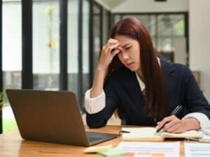 ragazza in burn out davanti al pc che vuole richiedere un recupero compensativo