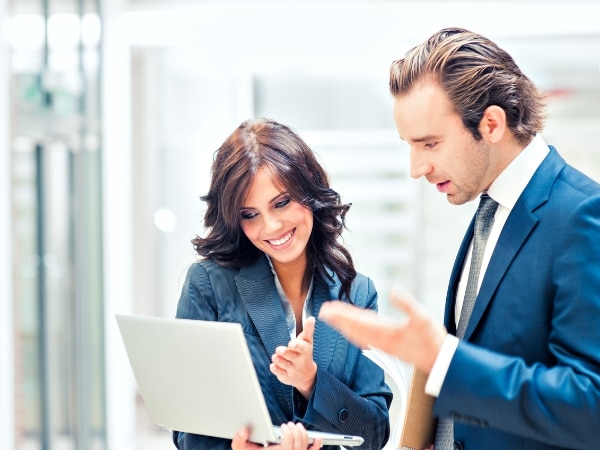 una donna e un consulente del lavoro esaminano un laptop, evidenziando la collaborazione per risolvere problemi.